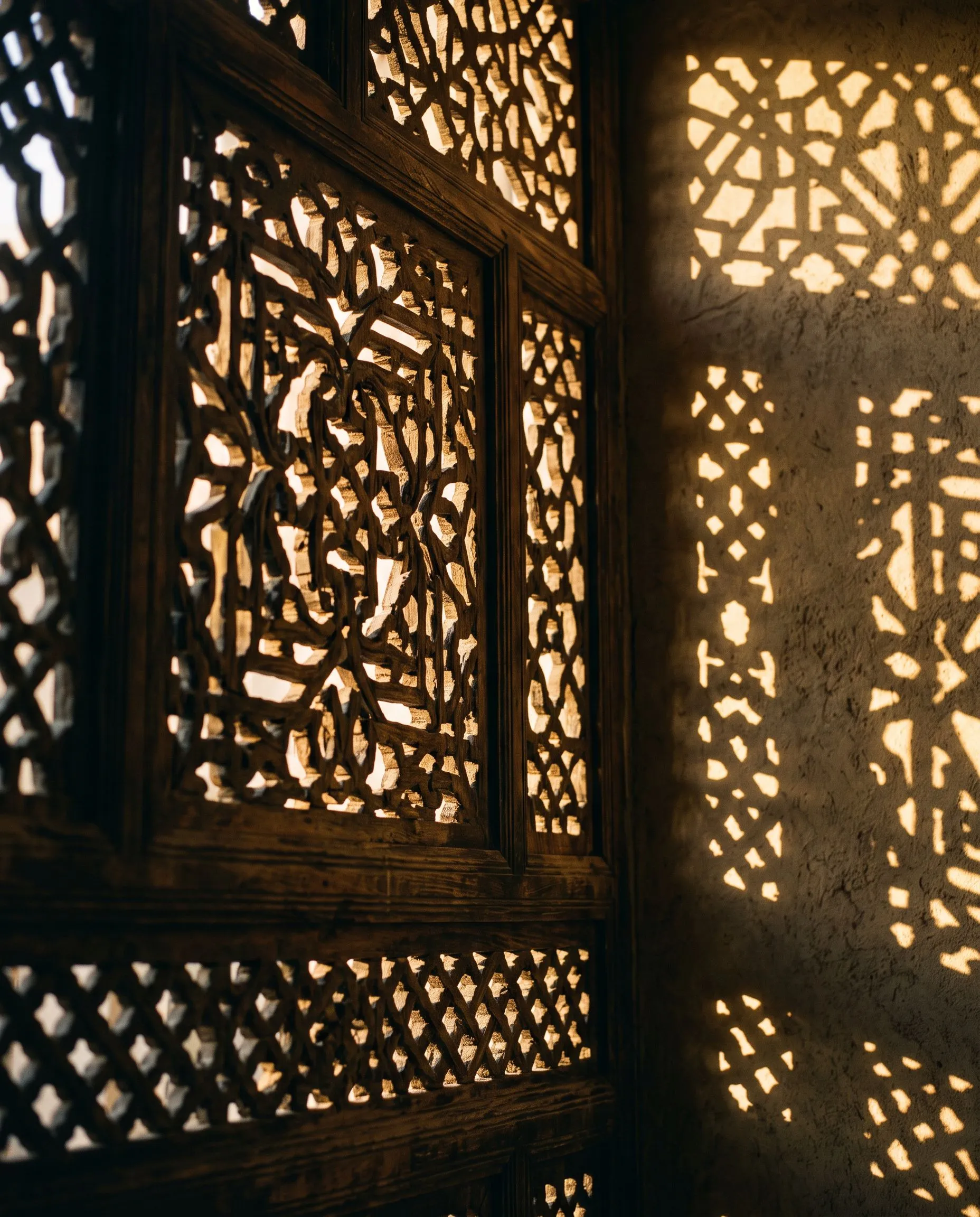 Carved mashrabiya screen casting a geometric shadow